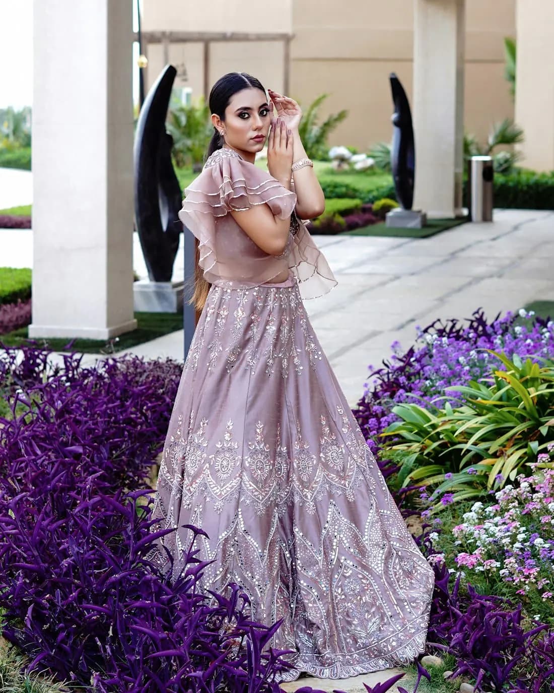 A woman in a lavender sequin lehenga in a garden