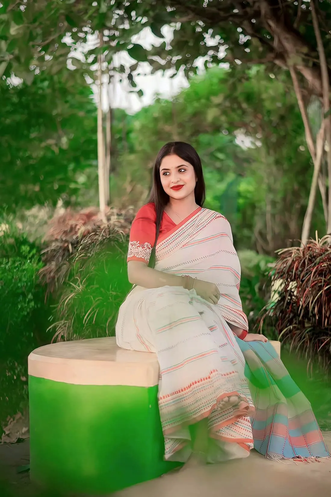 A woman in a cream tant saree with a coral border