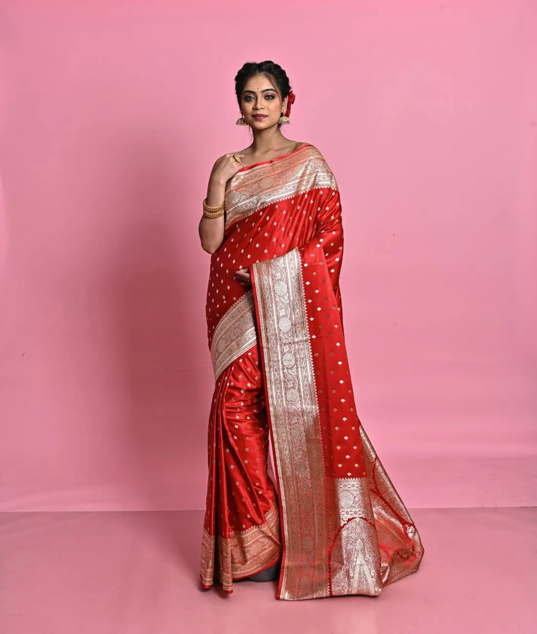 A woman in a red Banarasi saree with a gold border